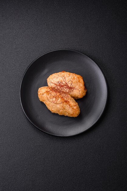 Heerlijke gebakken schnitzels of gehaktballetjes met zoute specerijen en kruiden op een donkere betonnen achtergrond