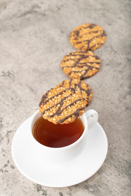 Heerlijke geglazuurde havermoutkoekjes met kopje thee op steen.