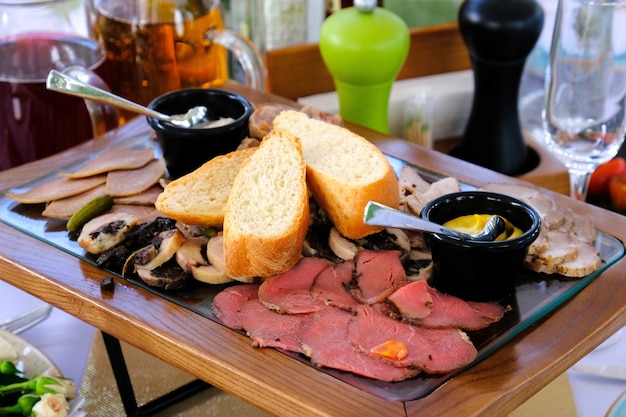 Heerlijke gerookte gesneden spek op een houten dienblad op een bankettafel in een luxe restaurant