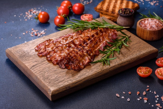 Heerlijke geroosterde ham met plakjes op een houten snijplank met specerijen en kruiden