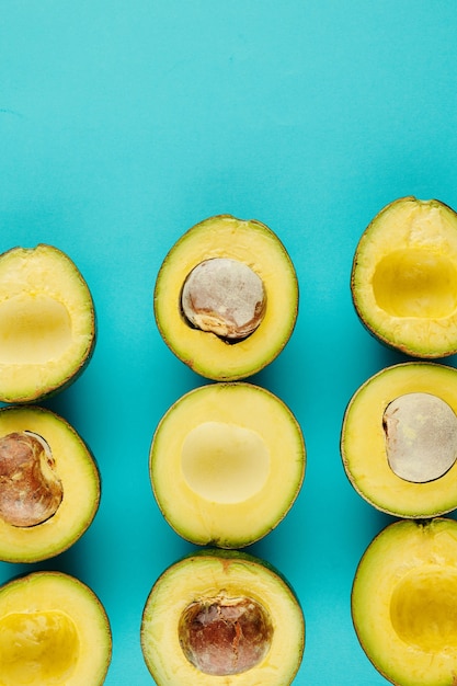 Heerlijke gesneden rijpe avocado's met en zonder klokhuis op lichtblauwe achtergrond