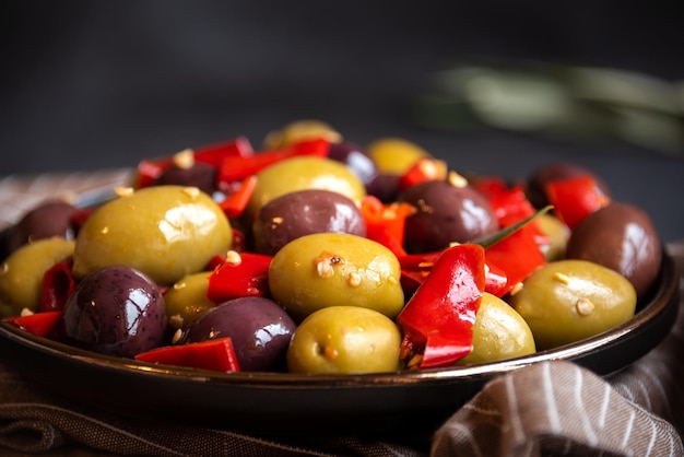 Heerlijke groene en rode olijven met rode chilipeper en olijfboombladeren gezond pittig voorgerecht