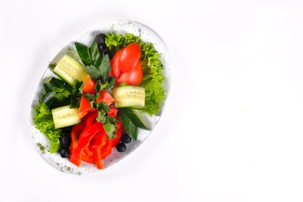 Heerlijke groentesalade van tomaten en komkommers met olijven op een bord op een geïsoleerde achtergrond