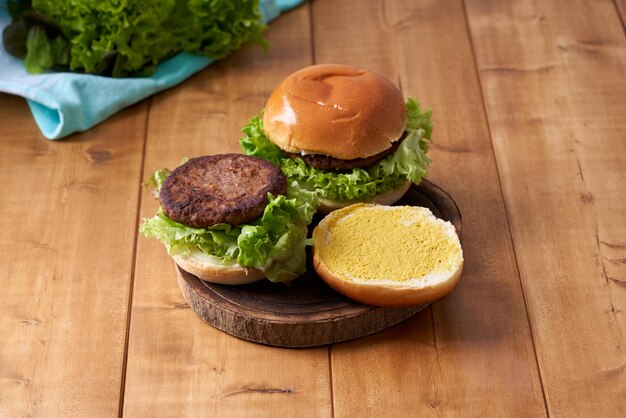 Heerlijke hamburger met groene salade op een houten tafel.