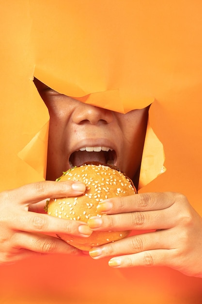 heerlijke hamburgers komen uit gescheurd oranje papier