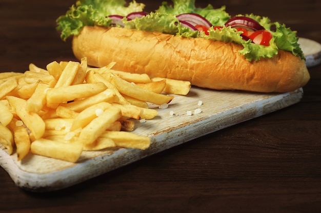 Heerlijke hotdog en friet op houten plank