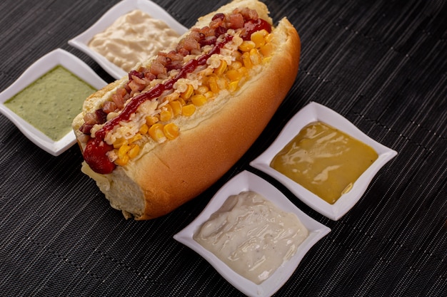 Heerlijke hotdog met ingrediënten en op kleurrijke of houten achtergrond