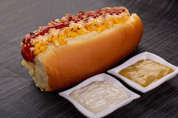 Heerlijke hotdog met ingrediënten en op kleurrijke of houten achtergrond