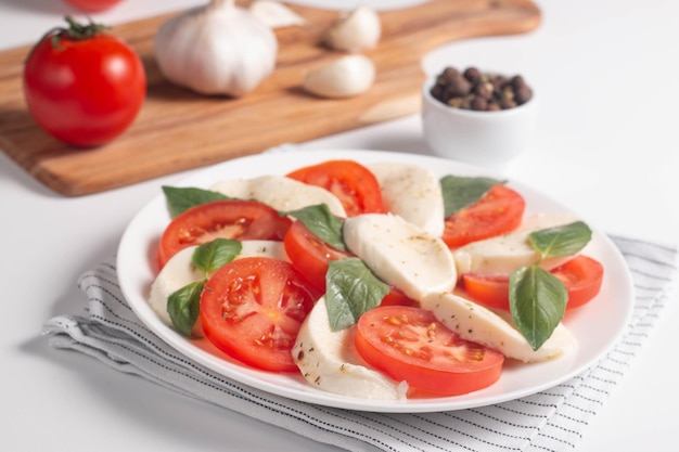 Heerlijke Italiaanse caprese salade met gesneden mozzarella tomaten basilicum pesto en knoflook op achtergrond