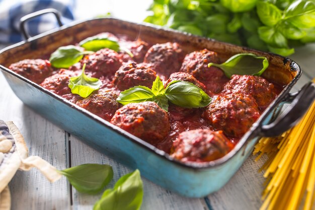 Heerlijke Italiaanse maaltijd vlees rundvlees ballen met pasta spaghetti en basilicum in vintage braadpan.