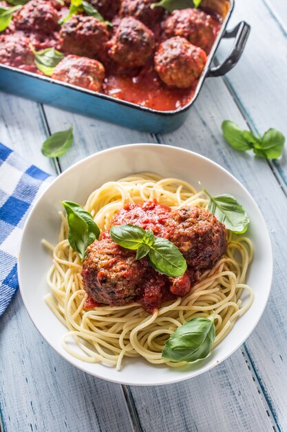 Heerlijke Italiaanse maaltijd vlees rundvlees ballen met pasta spaghetti en basilicum in witte plaat.