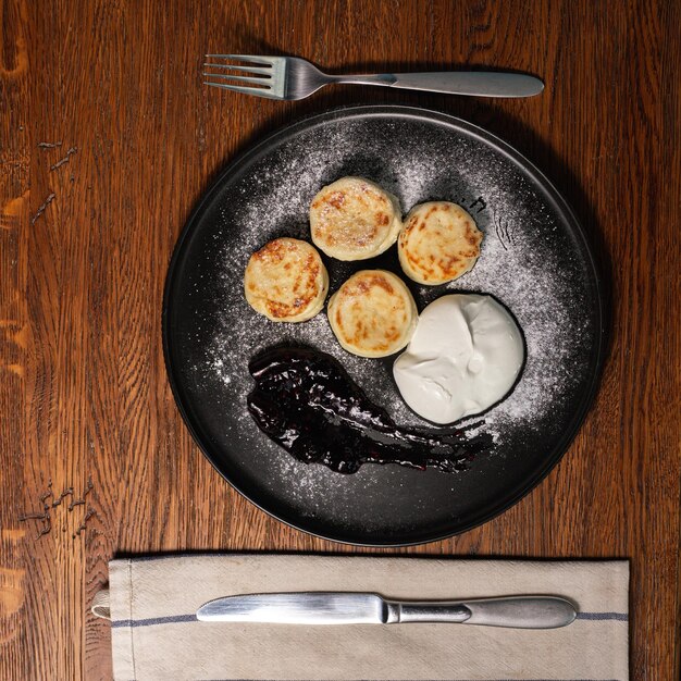 Foto heerlijke kaaspannenkoekjes geserveerd met bessenjam en zure room voor de lunch