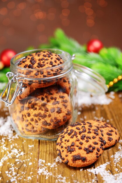 Heerlijke kerstkoekjes in pot op tafel op bruin oppervlak