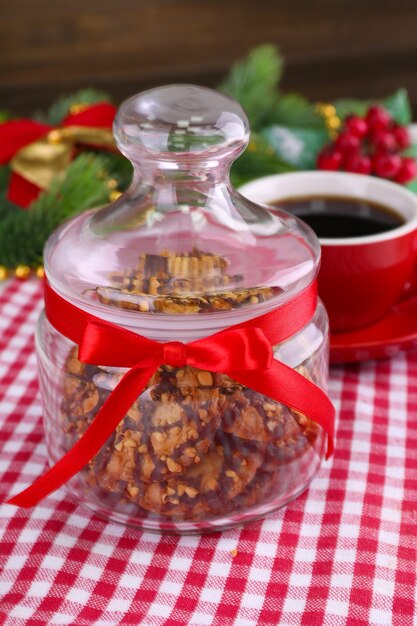 Heerlijke kerstkoekjes in pot op tafel op houten achtergrond