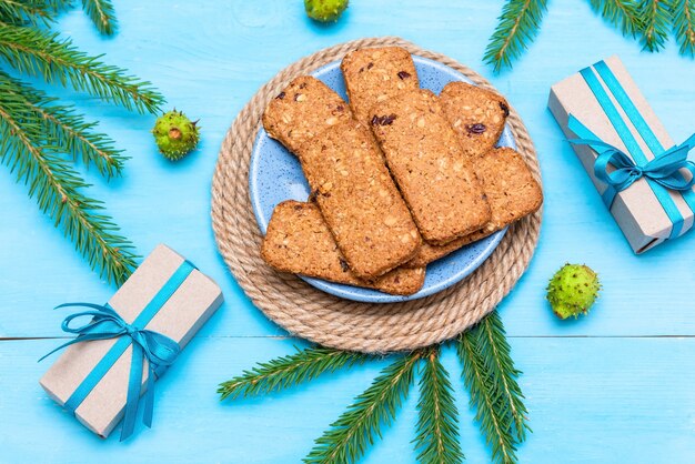 Heerlijke kerstkoekjes naast cadeautjes en dennenappels.