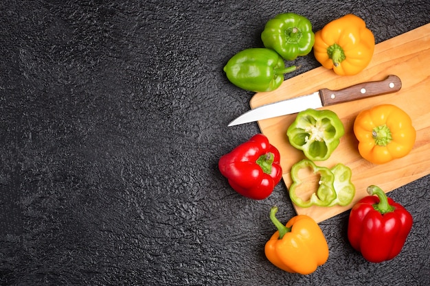 Heerlijke kleurrijke verse paprika's op de zwarte tafel