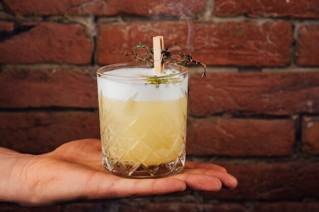 Heerlijke lichtgele cocktail van zuur schuim in het geëtste glas