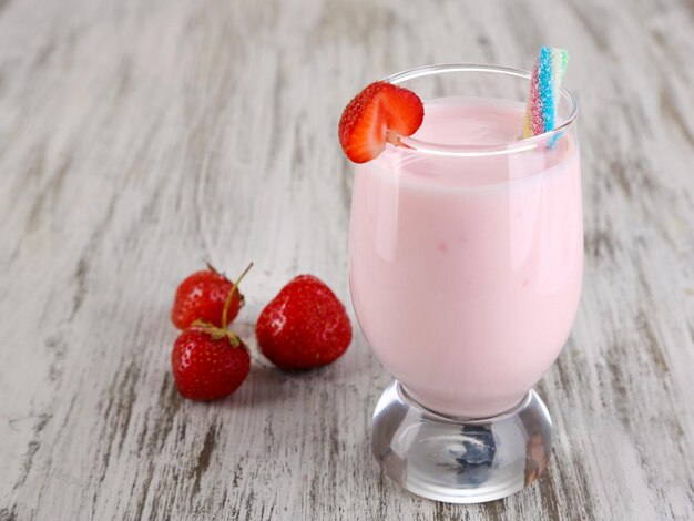 Heerlijke milkshake met aardbeien op houten tafel close-up