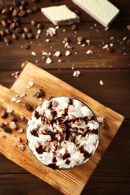 Heerlijke milkshake met chocoladesiroop en koffie op houten achtergrond