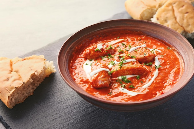 Heerlijke Murgh Makhani in kom op grijze achtergrond