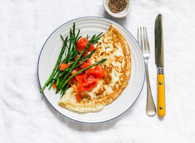 Heerlijke ontbijtbrunchomelet met asperges en gerookte zalm op een licht bovenaanzicht als achtergrond