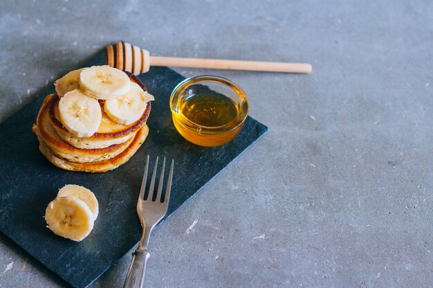 Heerlijke pannekoeken met banaan en honing op een ontbijt