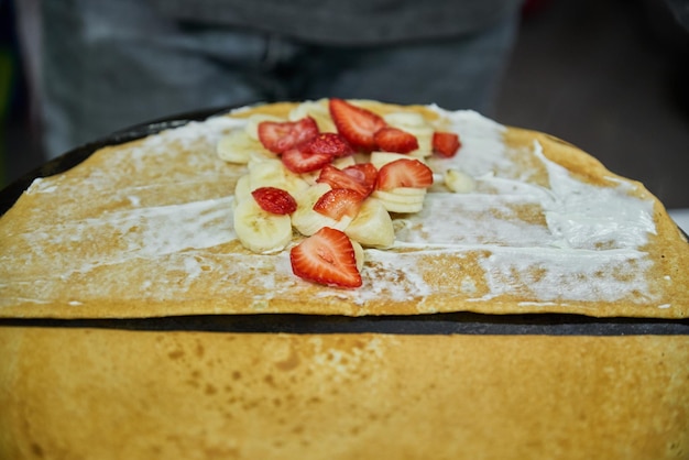 Heerlijke pannenkoeken maken op een grill met fruit en chocolade