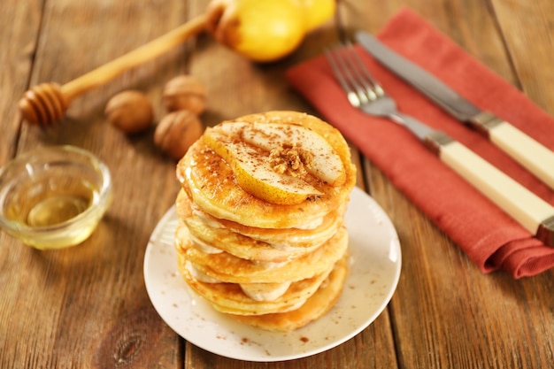 Heerlijke pannenkoeken met banaan en peer op houten tafel