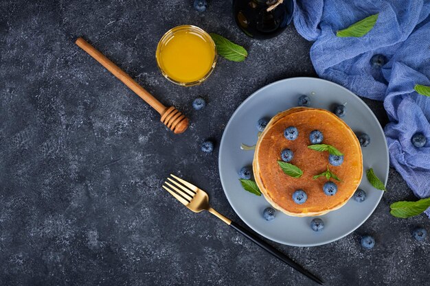 Heerlijke pannenkoeken met bosbessen en honing Zoete pannenkoeken met verse bessen