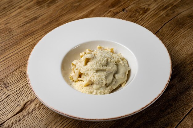 Heerlijke pasta met 4 soorten kaas en saus op een bord uit een restaurant