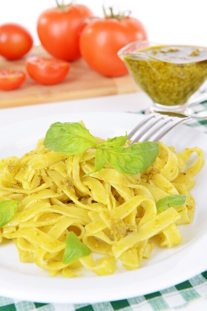 Heerlijke pasta met pesto op plaat op tafel close-up