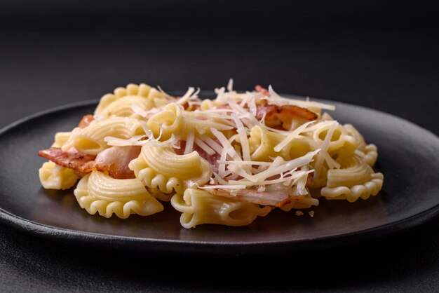 Heerlijke pasta met spek en Parmezaanse kaas op een zwarte keramische plaat