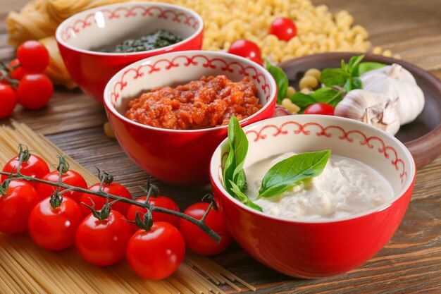 Heerlijke pesto bolognese en witte sauzen voor pasta in kommen op tafel