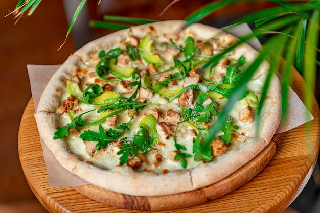 Heerlijke pizza met gegrilde kip avocado en rucola