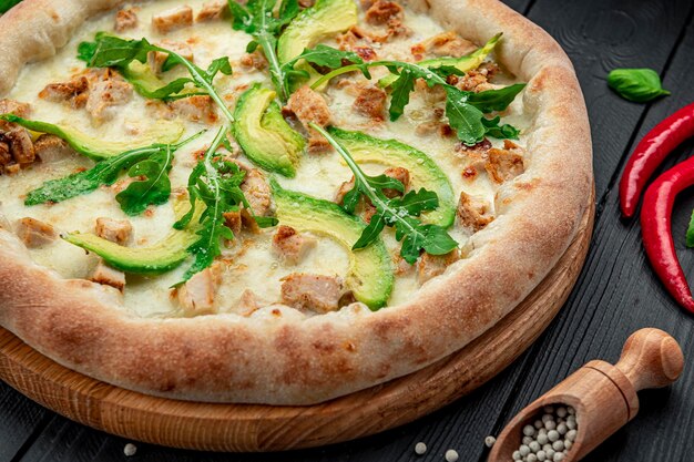 Heerlijke pizza met gegrilde kip avocado en rucola