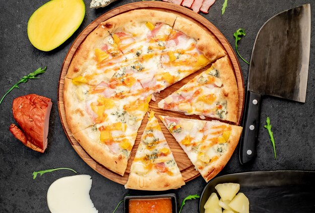 heerlijke pizza met ham kaas ananas mango op een stenen achtergrond