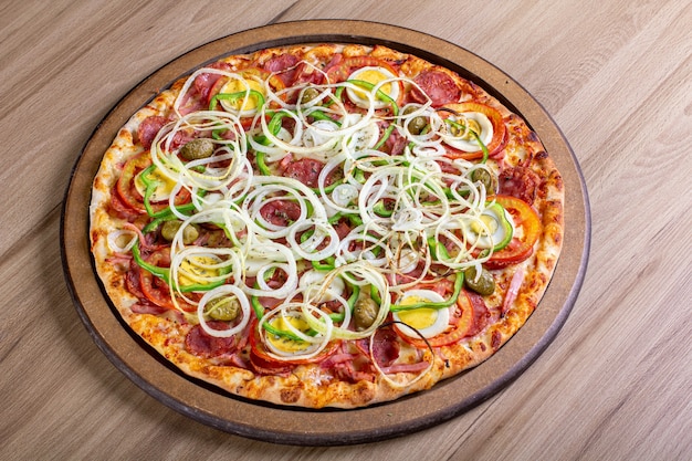 Heerlijke pizza met veel vulling op een houten tafel