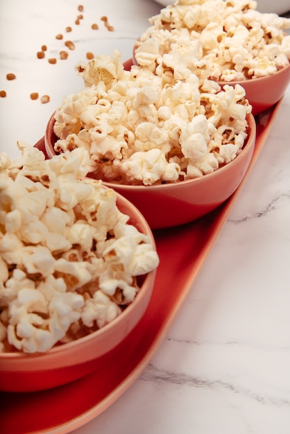 Heerlijke popcorn in drie rode keramische kommen