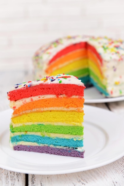 Heerlijke regenboogcake op bord op tafel op lichte achtergrond