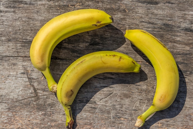 Heerlijke rijpe gele bananen op rustieke houten tafel. Bovenaanzicht