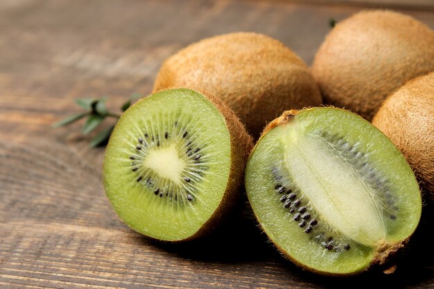 Heerlijke rijpe veel kiwi's en kiwi's in een snee op een bruin houten tafel. detailopname.