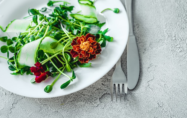 Heerlijke salade met bloemen, vork en mes