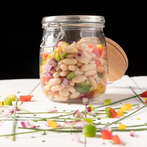 Foto heerlijke saladeboon in een kruik vooraanzicht op zwarte achtergrond