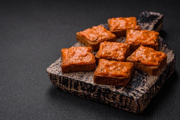 Heerlijke sandwich bestaande uit toast rode saus met zoute specerijen en kruiden op een donkere betonnen achtergrond