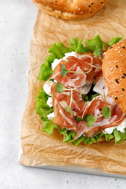 Heerlijke sandwich met prosciutto roomkaas en microgreens voor ontbijt bagel met ham