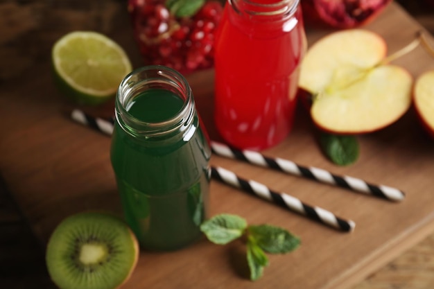 Heerlijke sappen in flessen en fruit op een houten bord