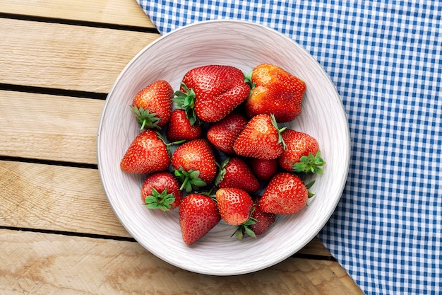 Heerlijke sappige aardbeien op de plaat met houten achtergrond.