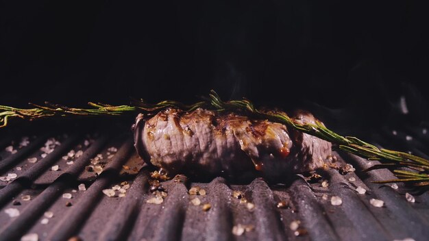 Heerlijke sappige vleesbiefstuk koken op grill prime beef fry op elektrische braadpan rozemarijn zwarte peper zout slow motion