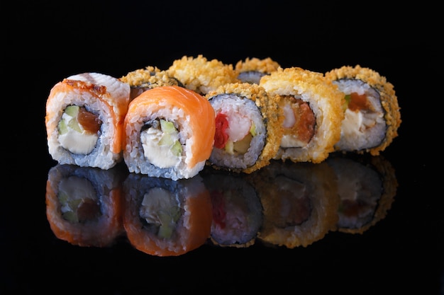 Heerlijke set sushi roll met vis op een zwarte achtergrond met reflectie Menu en restaurant