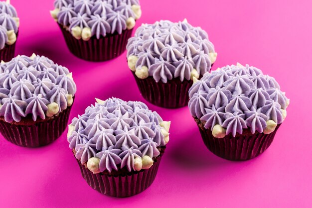 Heerlijke shawn cupcakes met kwarkcrème in de vorm van bloemen op een roze ondergrond